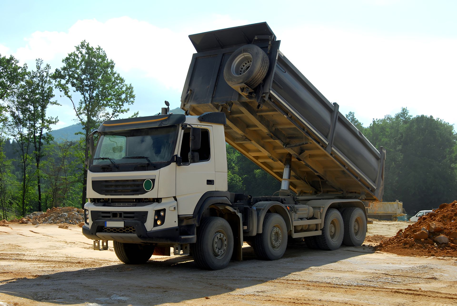 White Dump Truck, Bed Raised, Unloading Material — Compass Equipment Hire in Kyogle, NSW