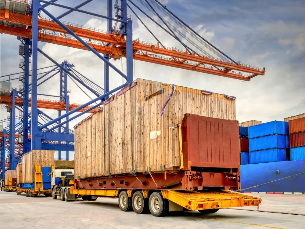 Trucks Carrying Wooden Crates at a Port — Compass Equipment Hire in Woolgoolga, NSW