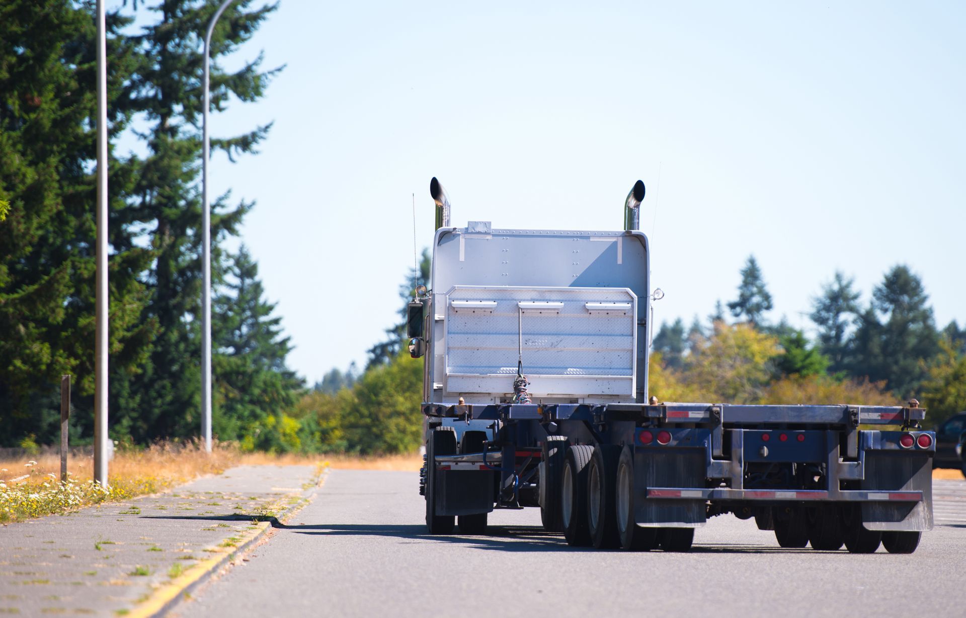 Rear View of a Silver Semi-Truck With a Flatbed Trailer — Compass Equipment Hire in Iluka, NSW