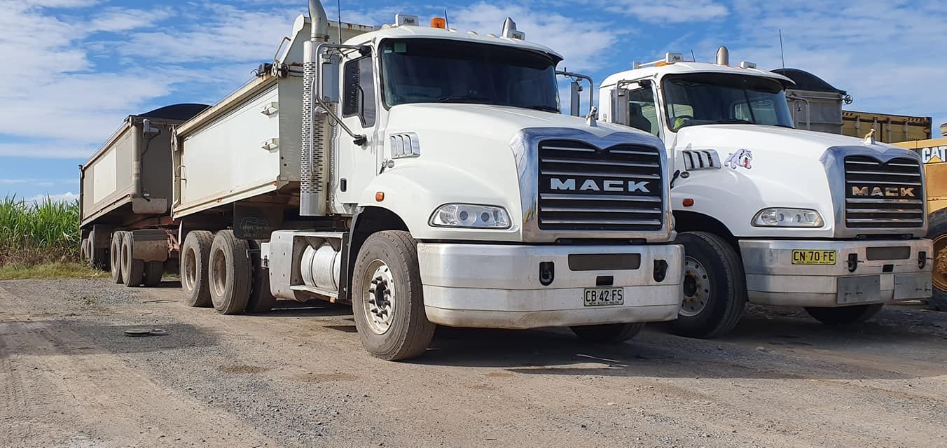 Two White Mack Dump Trucks Parked — Compass Equipment Hire in Woodburn, NSW