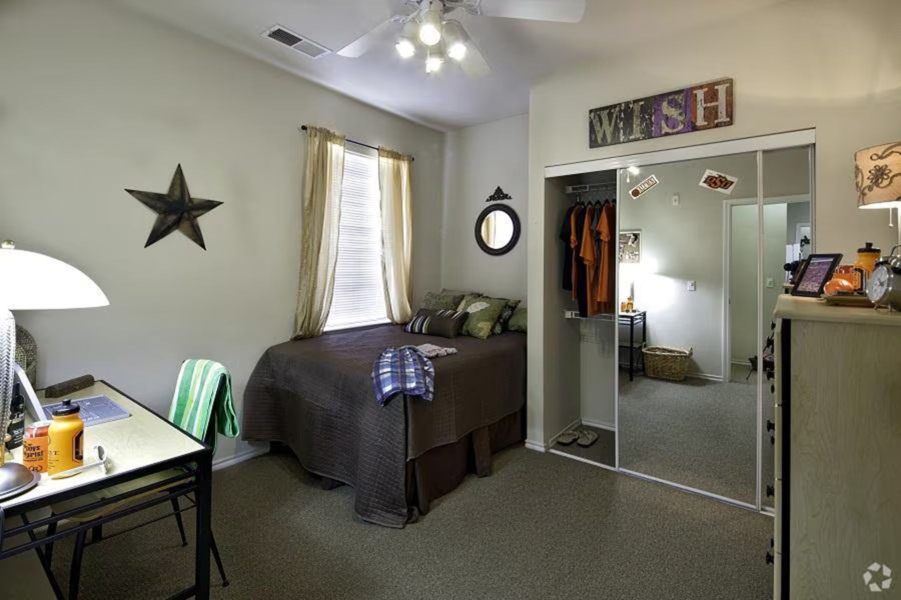Spacious furnished bedroom at Milestone Stillwater with décor, study desk, and mirrored closet doors.
