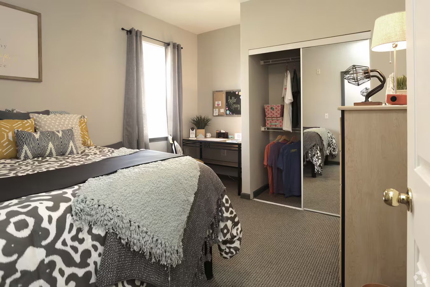 Modern furnished bedroom at Milestone Stillwater with bed, side table, and open closet.