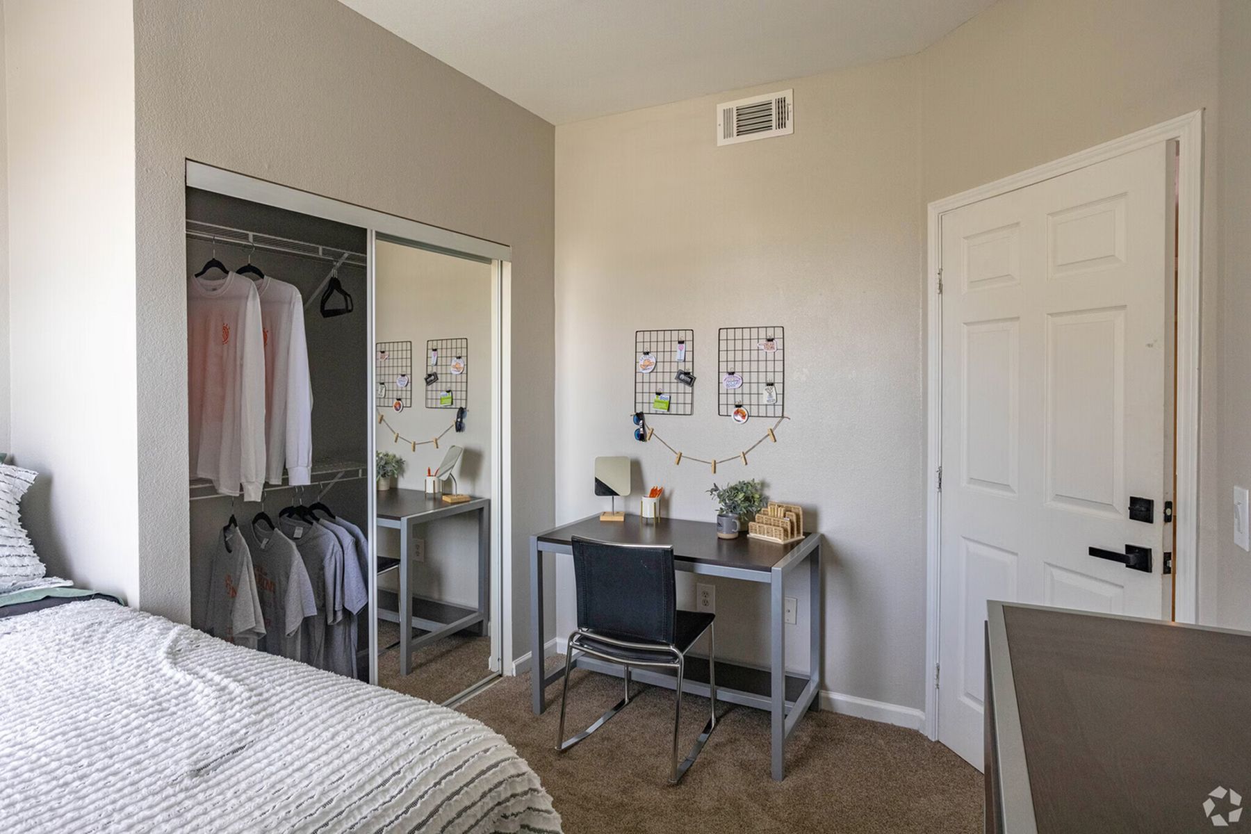 Student bedroom at Milestone Stillwater featuring study desk, bed, and organized closet space.