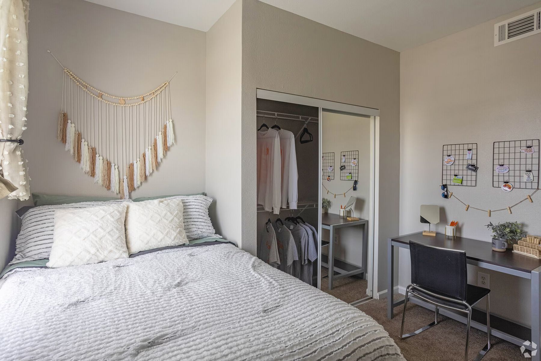 Furnished student bedroom at Milestone Stillwater with bed, desk, and open closet.