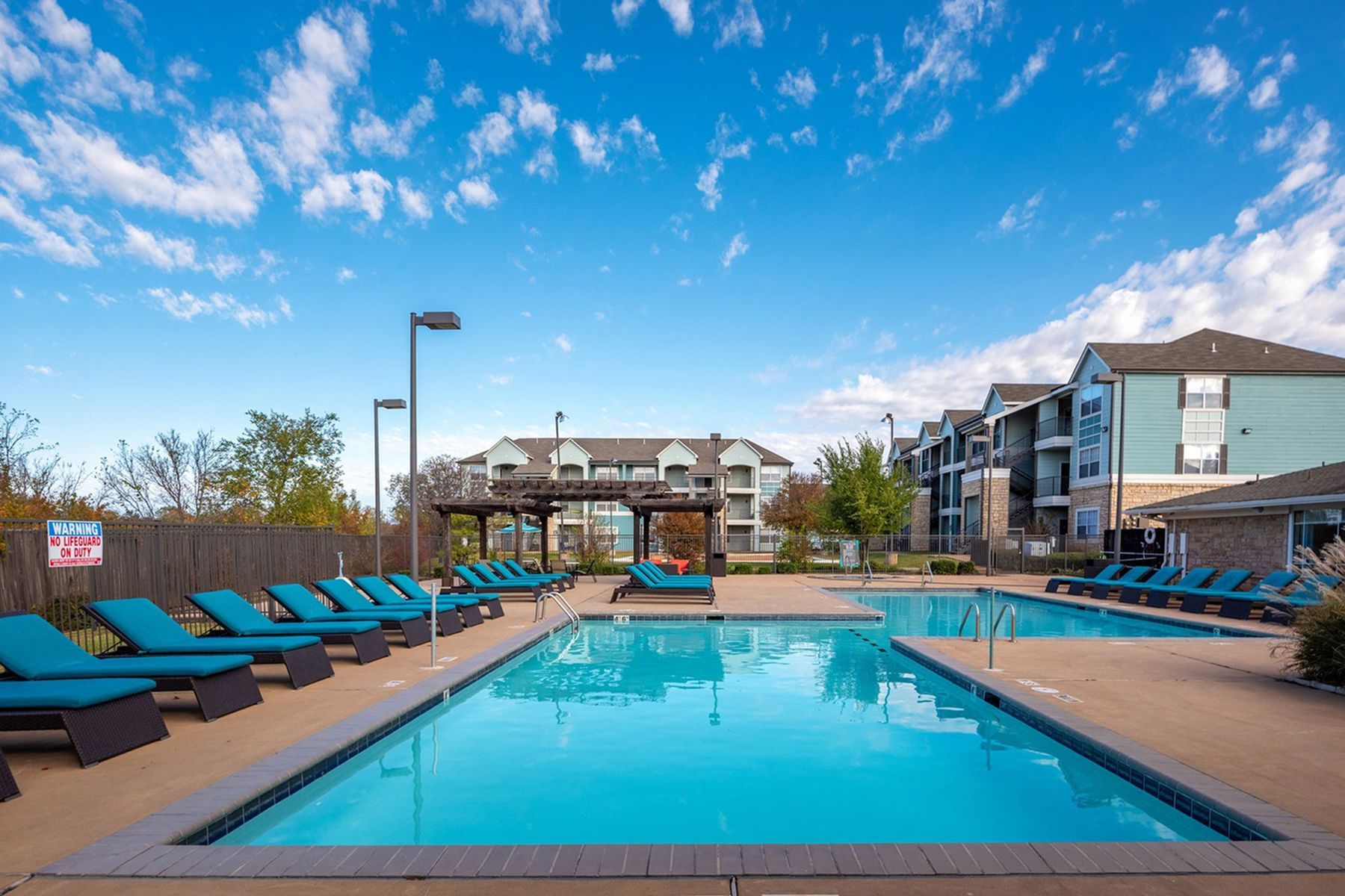 Resort-style pool at Milestone Stillwater with lounge chairs and landscaped courtyard.