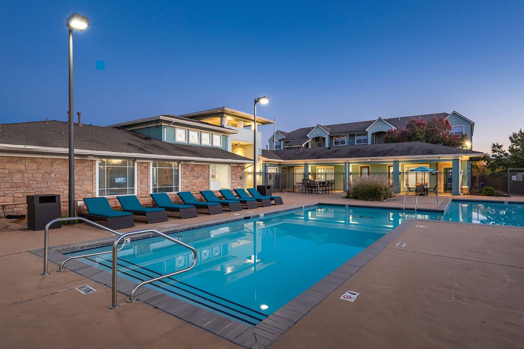 Resort-style pool at Milestone Stillwater student apartments with lounge seating.