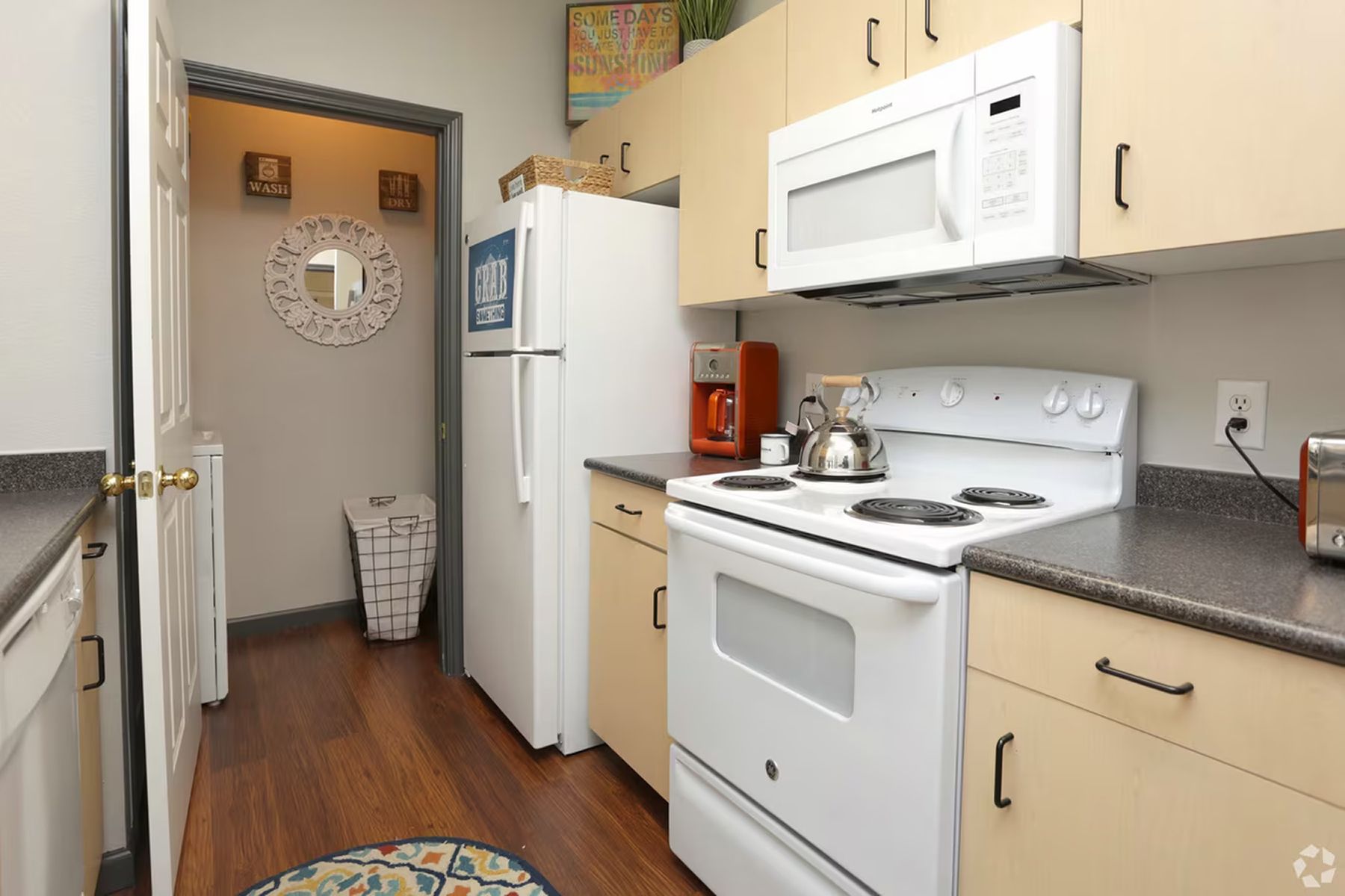 Fully equipped kitchen at Milestone Stillwater with white appliances and overhead cabinets.