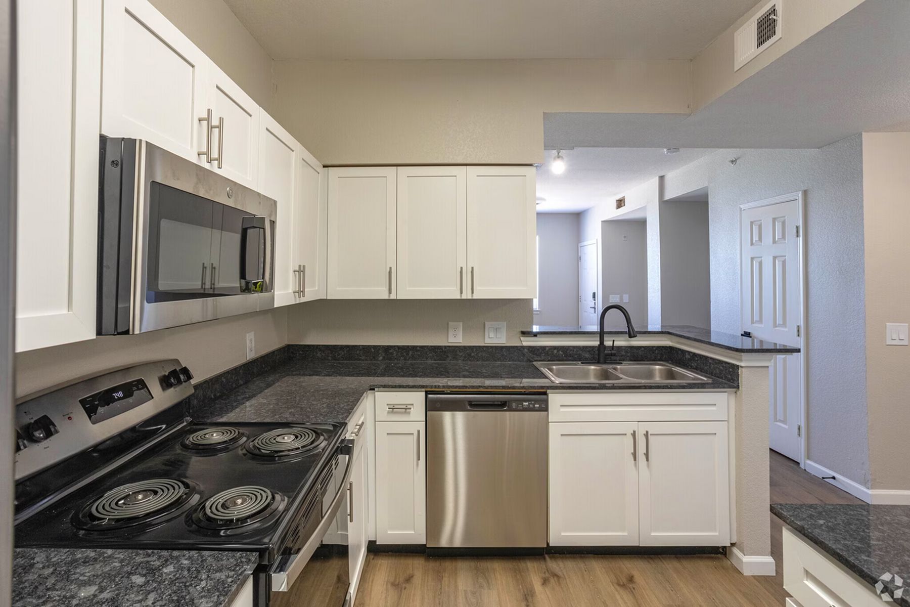 Modern kitchen at Milestone Stillwater featuring stainless steel appliances and dark countertops.