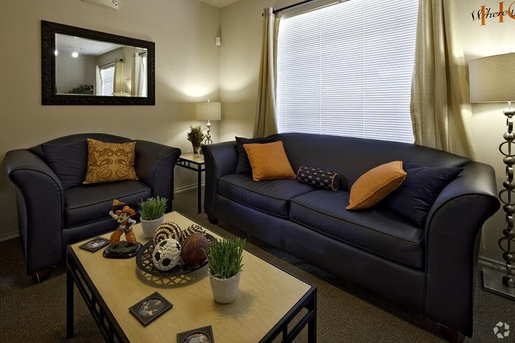 Cozy furnished living room at Milestone Stillwater with dark sofas and warm lighting.