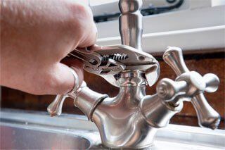 Using Wrench for Plumbing Repair on Kitchen Sink