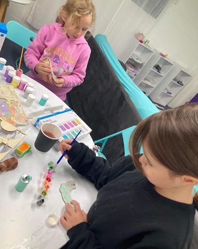 Two Young Girls Are Sitting at a Table Painting — Learn to Live in Currajong, QLD