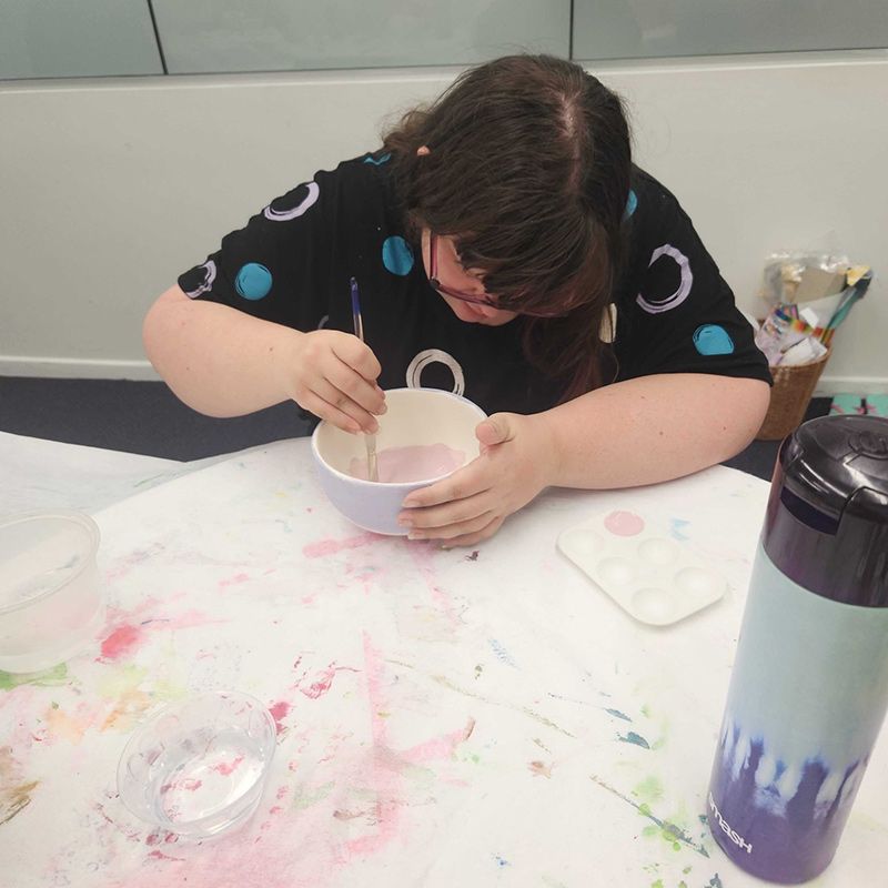 A Woman Carefully Painting a Bowl With Colourful Paint — Learn to Live in Kirwan, QLD