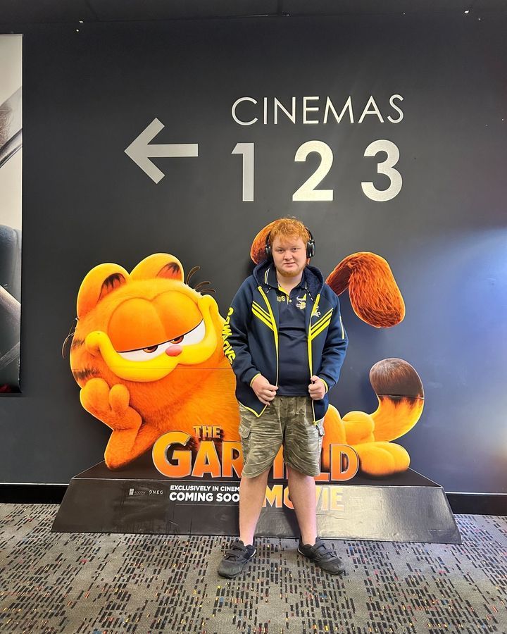 A Man Smiling in Front of a Movie Poster — Learn to Live in Currajong, QLD