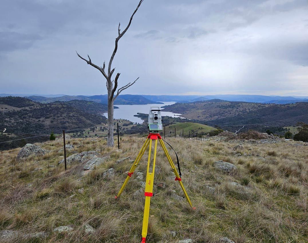 Surveyor With Electronic Distance Measure Device and A View Of A Lake In The Background — Surveyor In Canowindra, NSW