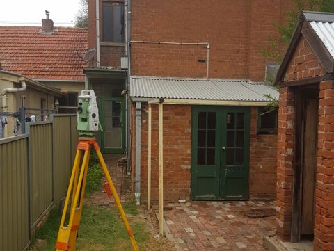 Surveyor In Front Of A Brick Building — Surveyor In Young, NSW