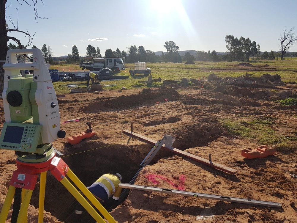Worker Digging Under a Surveyor on The Construction Site — Surveyor In Young, NSW