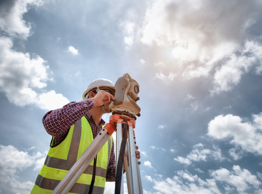 Worker Observing Through the  Surveyor With Sky Background — Surveyor In Blayney, NSW