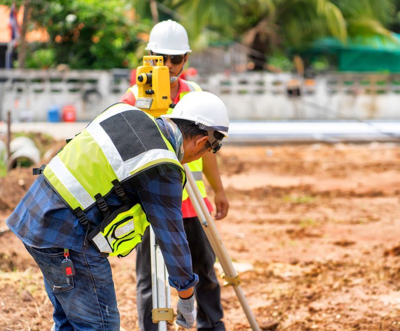 Two Workers Are Working On A Construction Site Using Surveyor — Surveyor In Canowindra, NSW