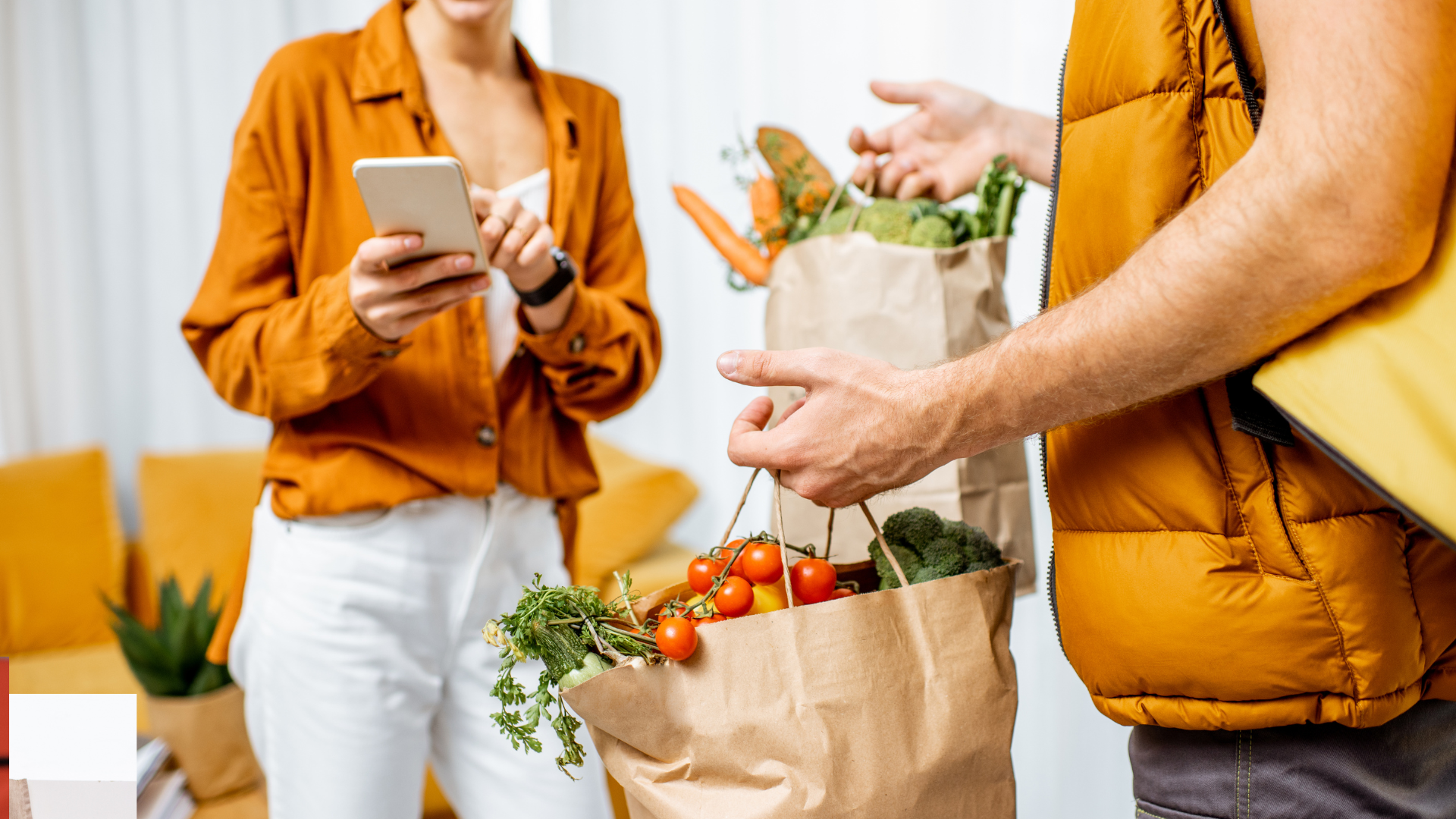 A man is delivering groceries to a woman who is using a tablet.