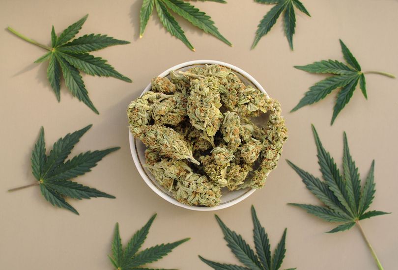 A watercolor painting of a building with flowers in front of it.