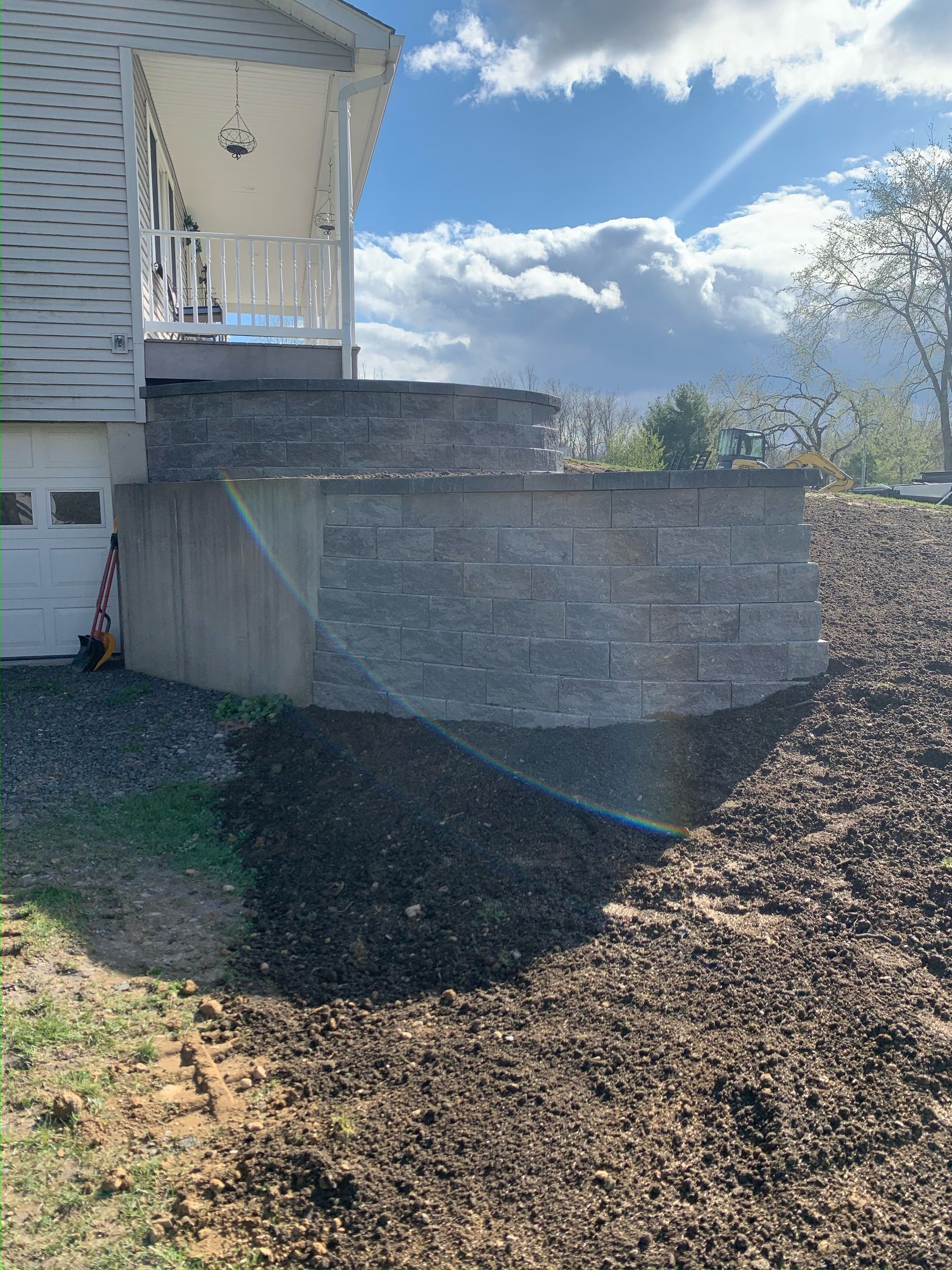 There is a large pile of dirt in front of a house.