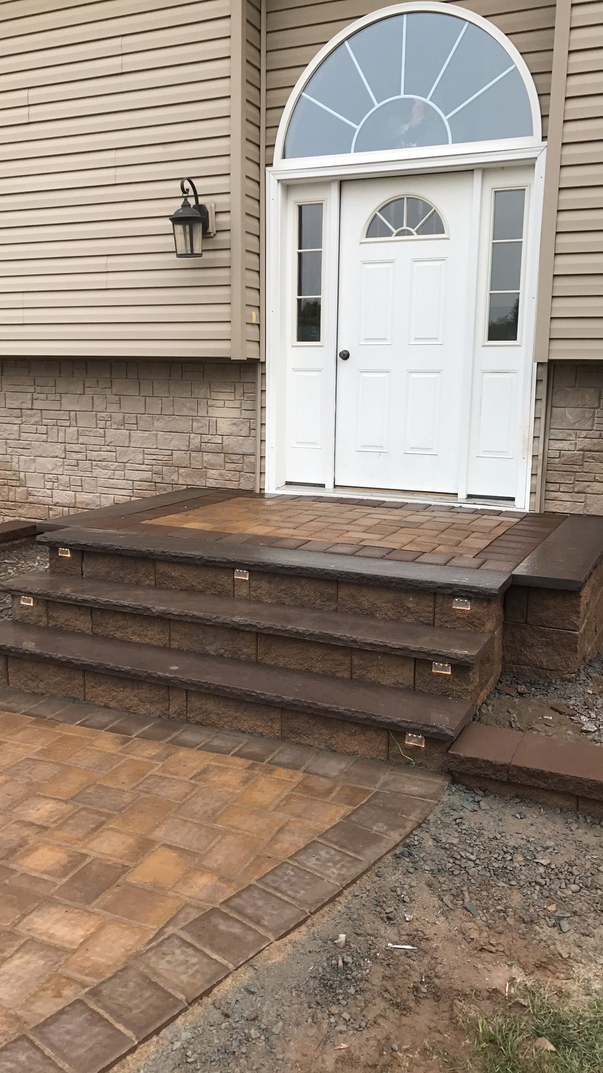 The front door of a house with stairs leading up to it.