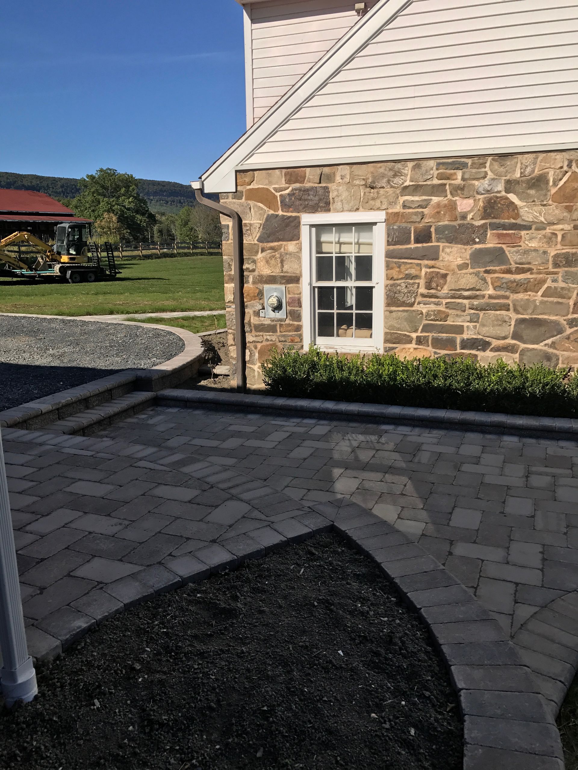 A stone house with a white siding and a window