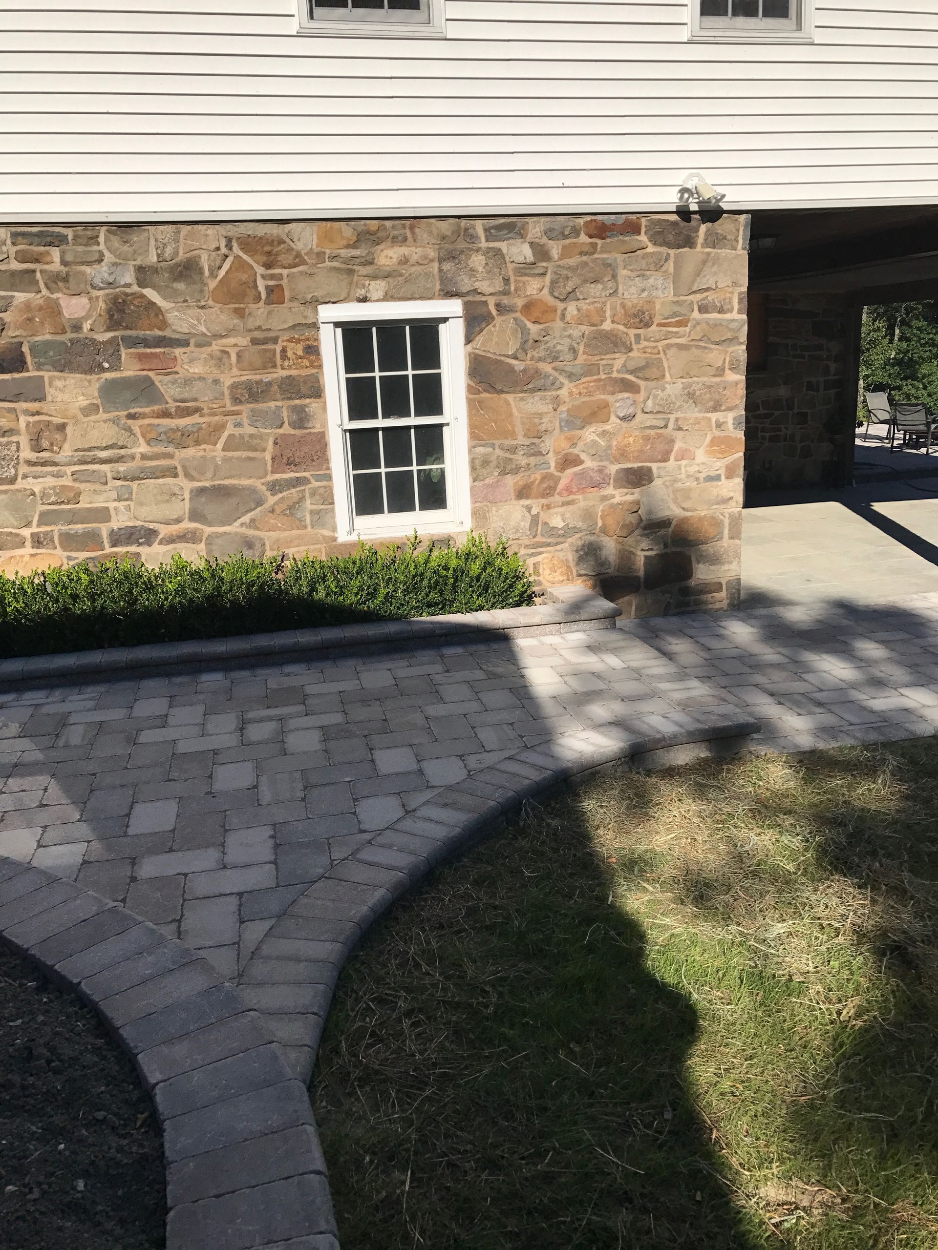 A stone house with a brick walkway leading to it