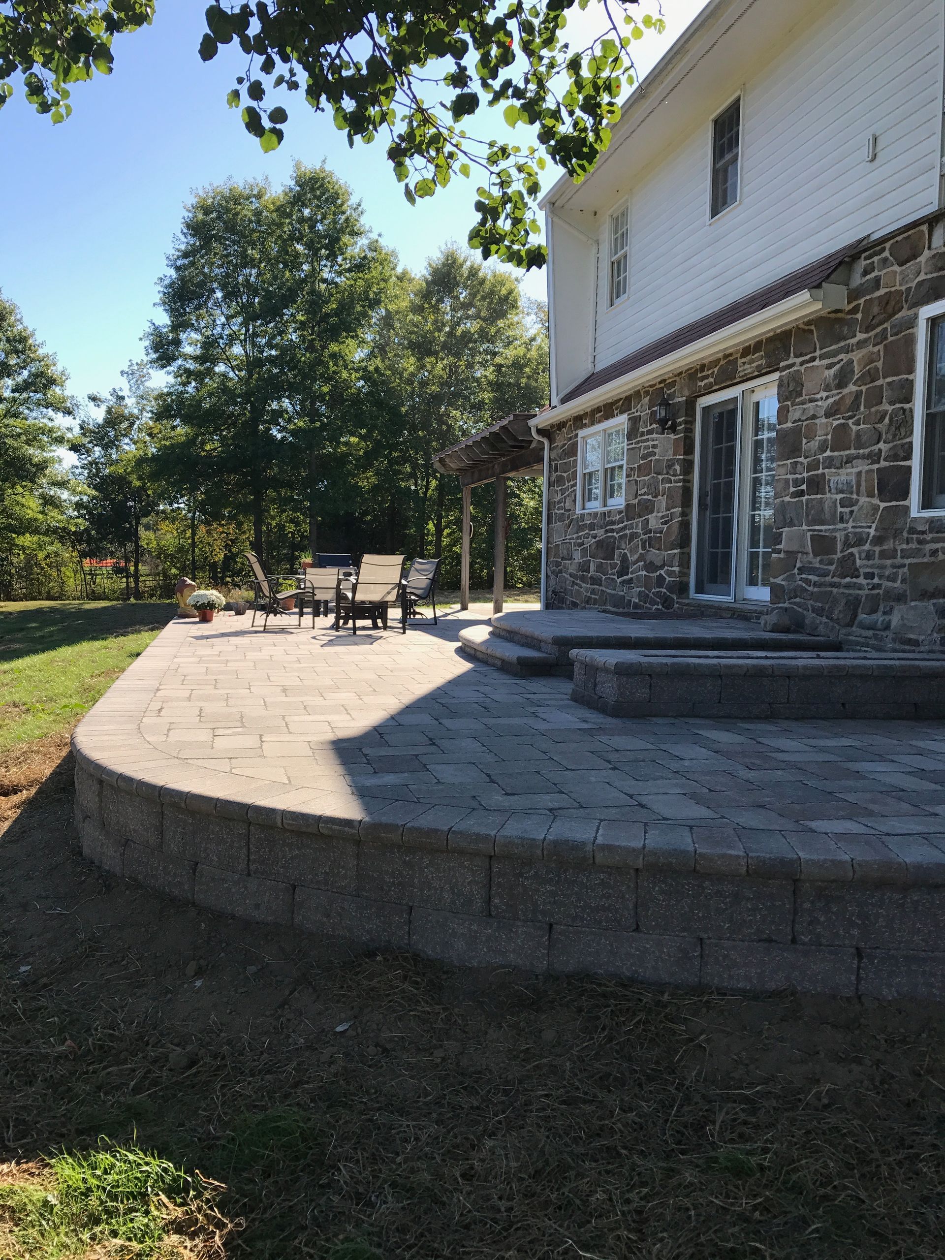 A large stone house with a patio in front of it