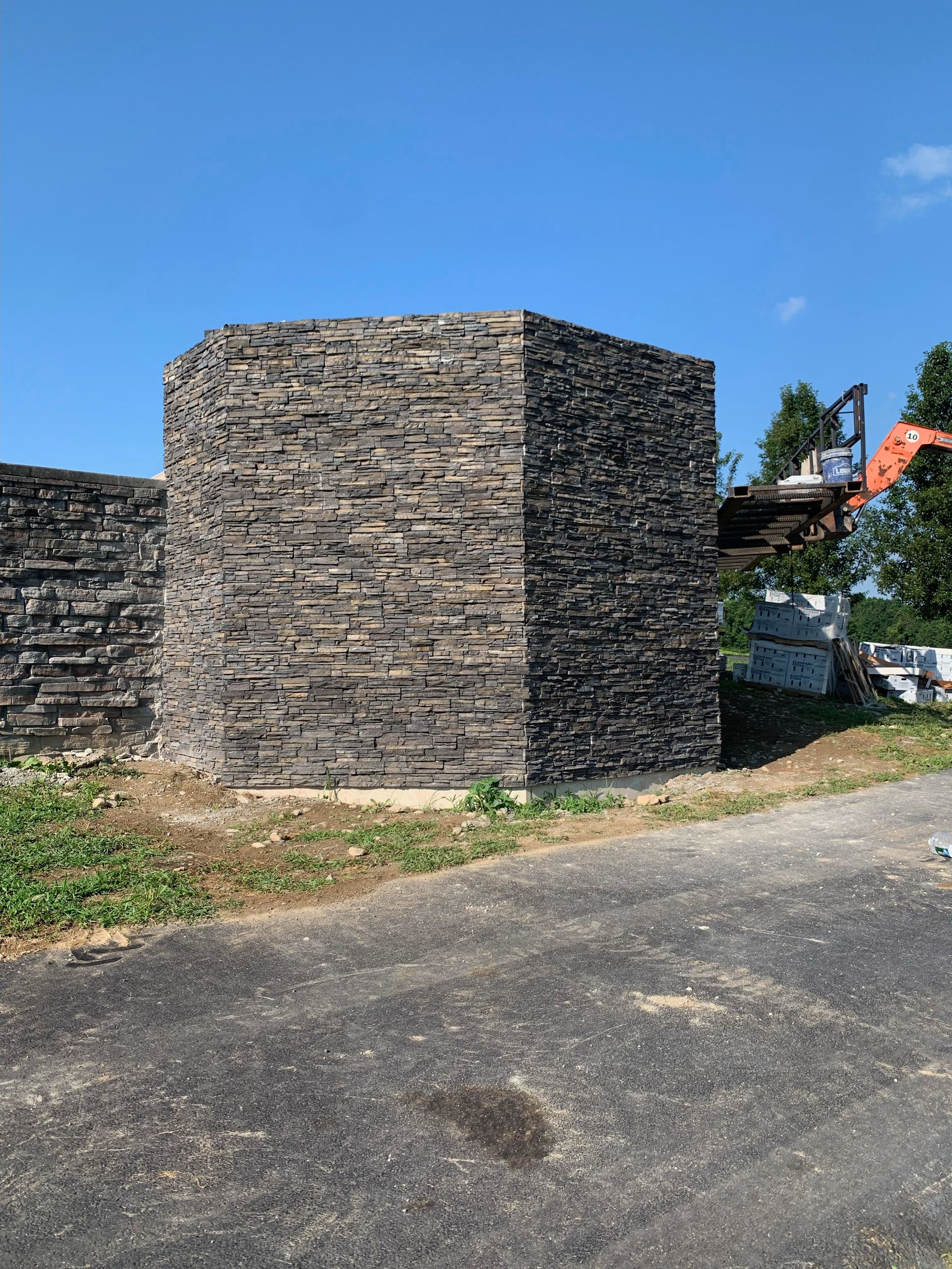 A large stone tower is sitting on the side of a road.