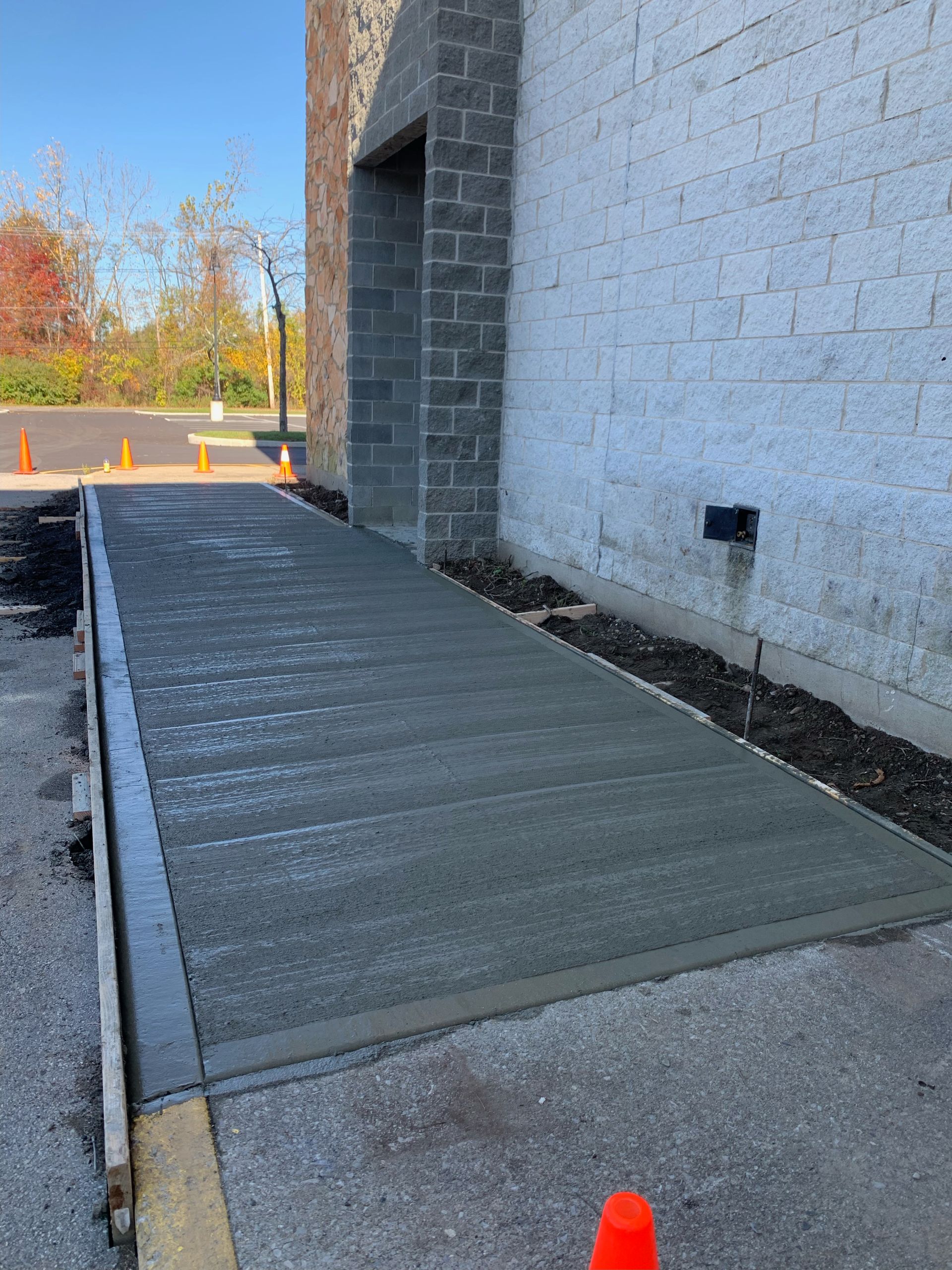 A concrete ramp is being built in front of a brick building.