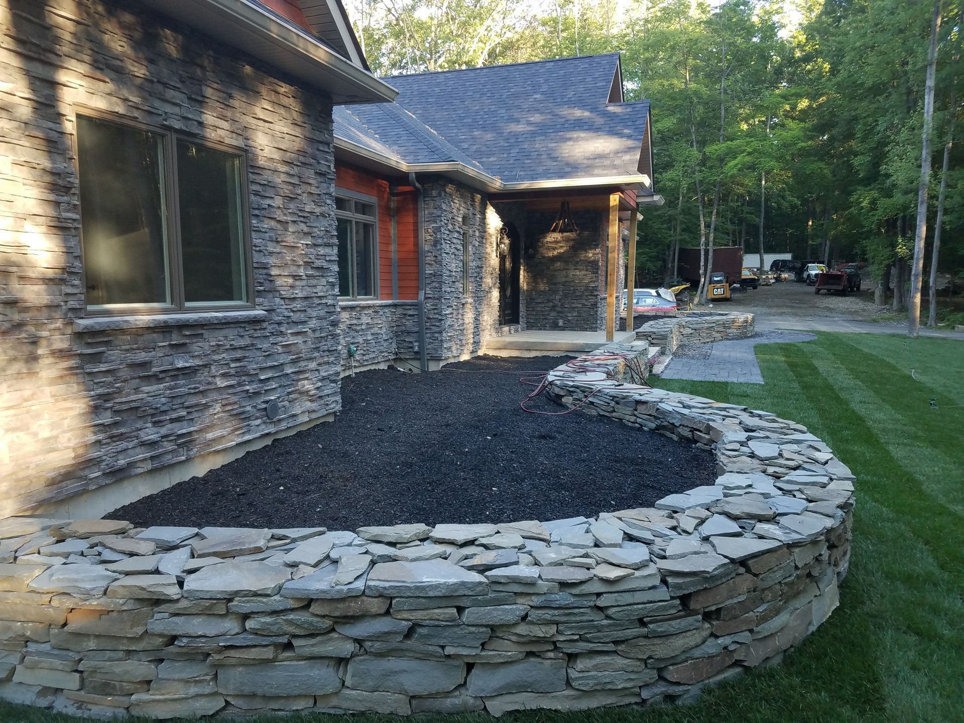 A house with a stone wall in front of it