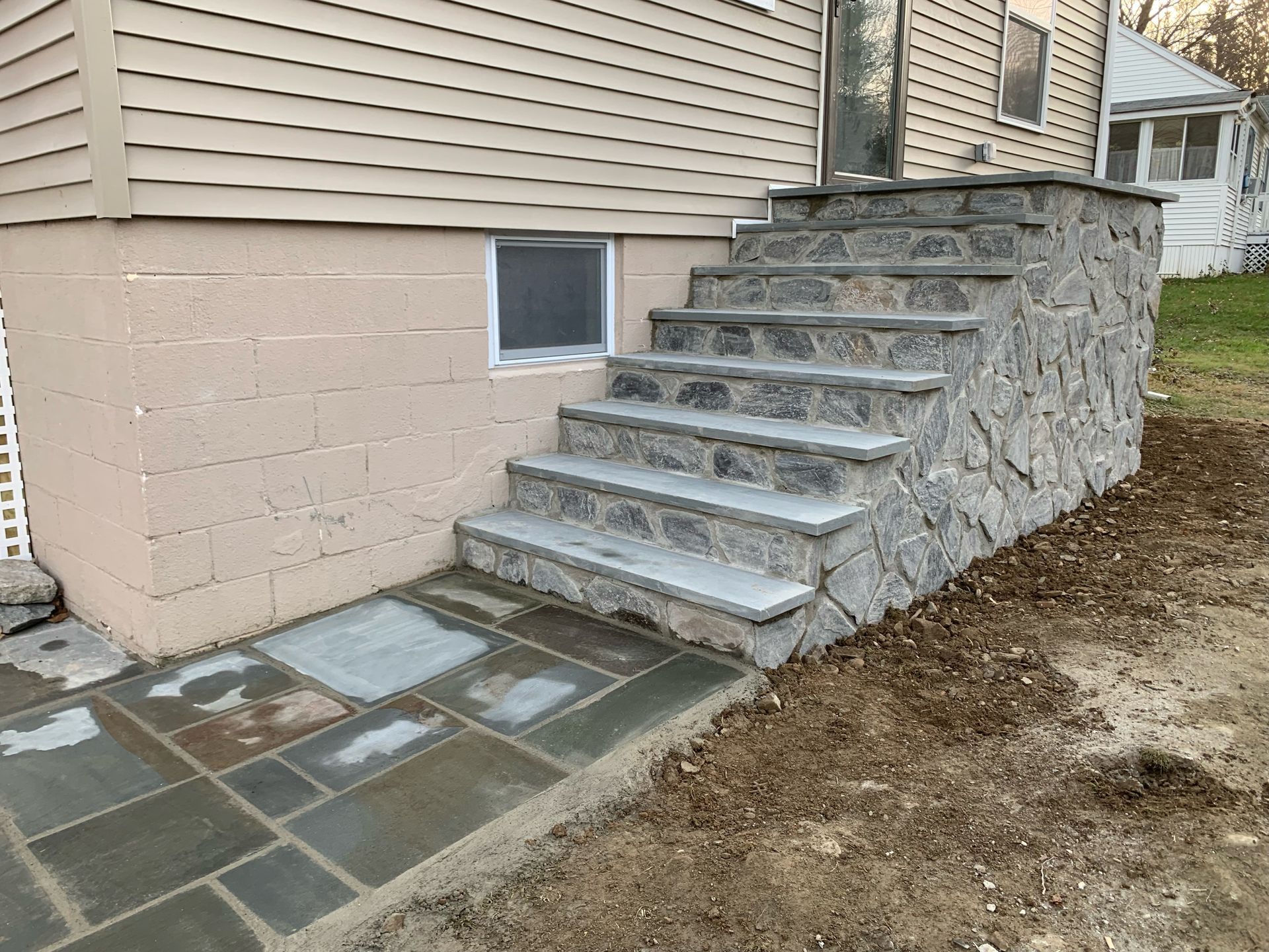 A stone walkway with stairs leading up to a house.