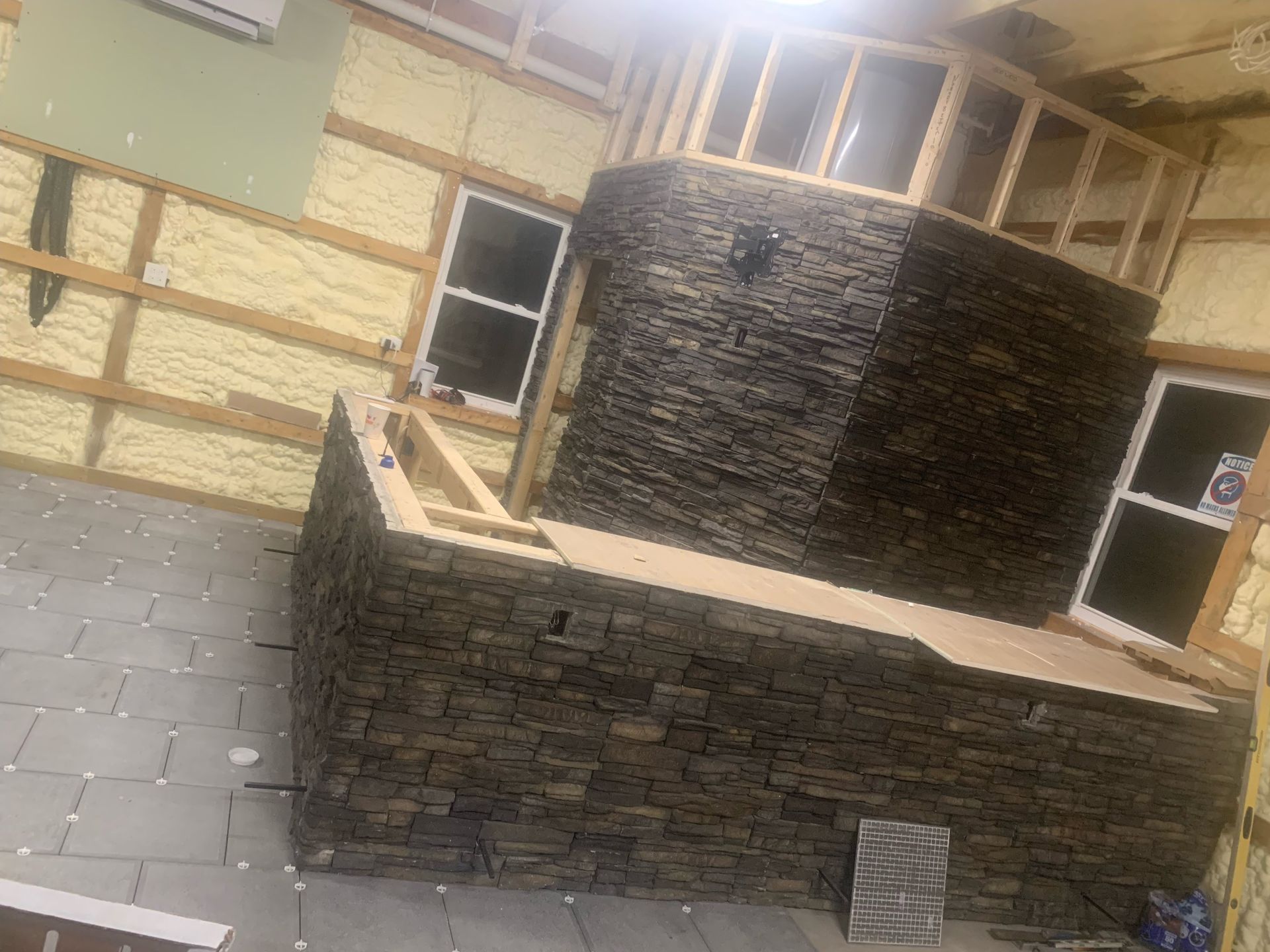 A room with a stone wall and a fireplace in it.