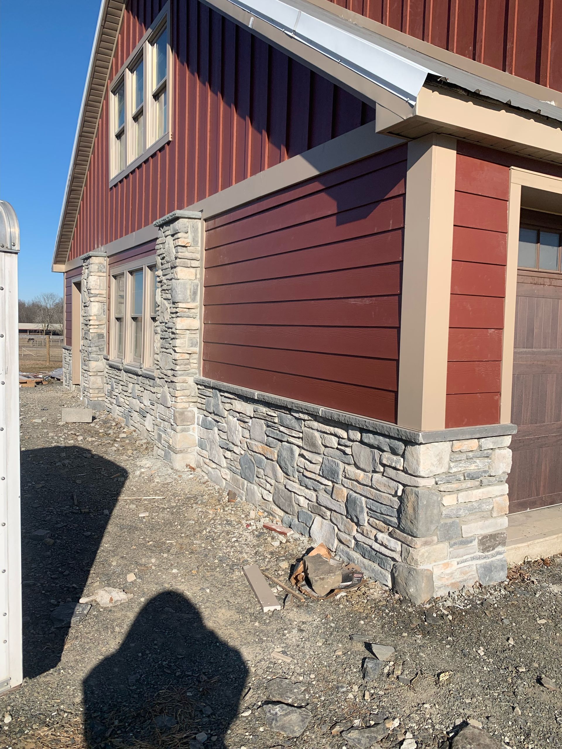 A house with a red siding and stone foundation