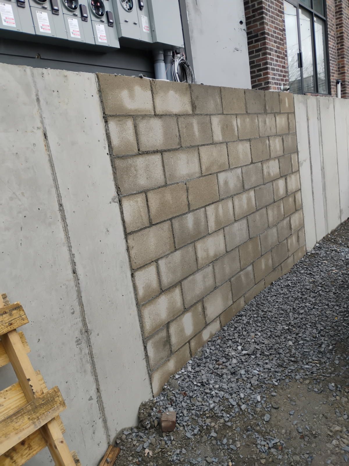 A brick wall is being built on the side of a building.