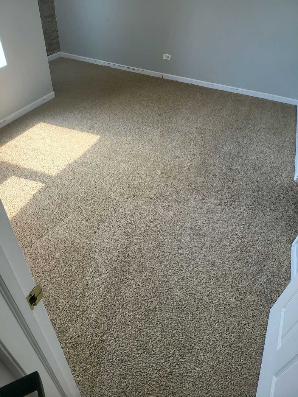 After image of a bedroom with a carpeted floor and a window