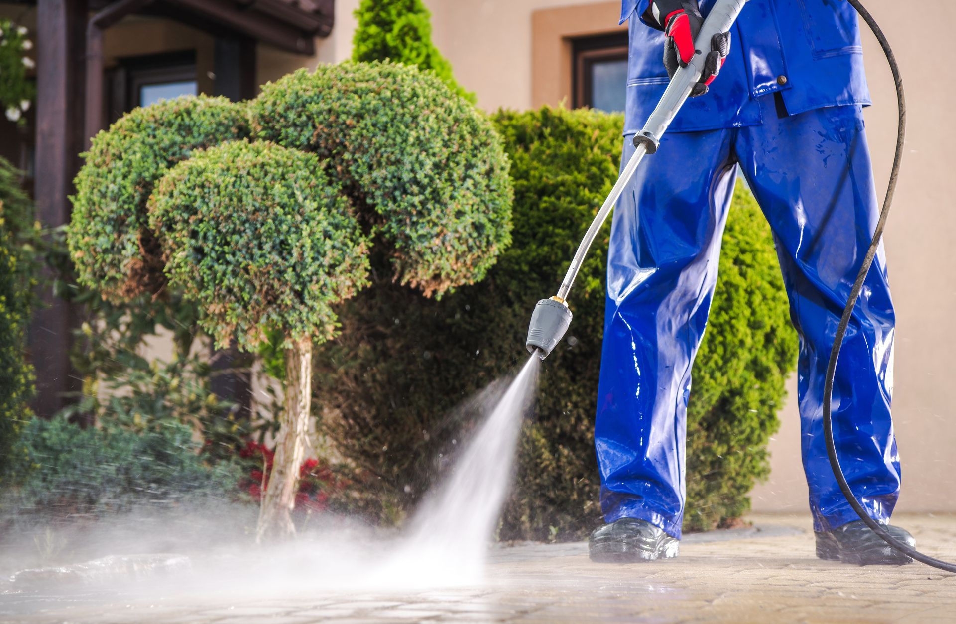 a man is using a high pressure washer to clean a sidewalk in front of a house