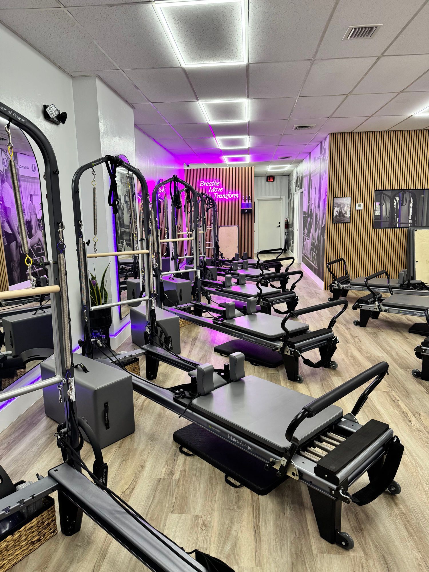 A pilates studio with a lot of pilates machines and mirrors
