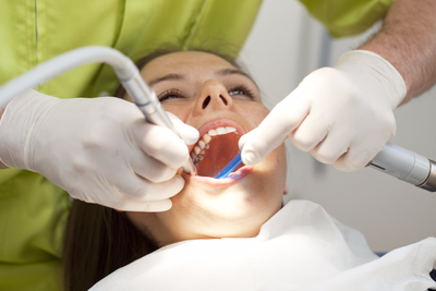 Teeth Whitening — Dentist Cleaning the Teeth of a Woman in Sacramento, CA