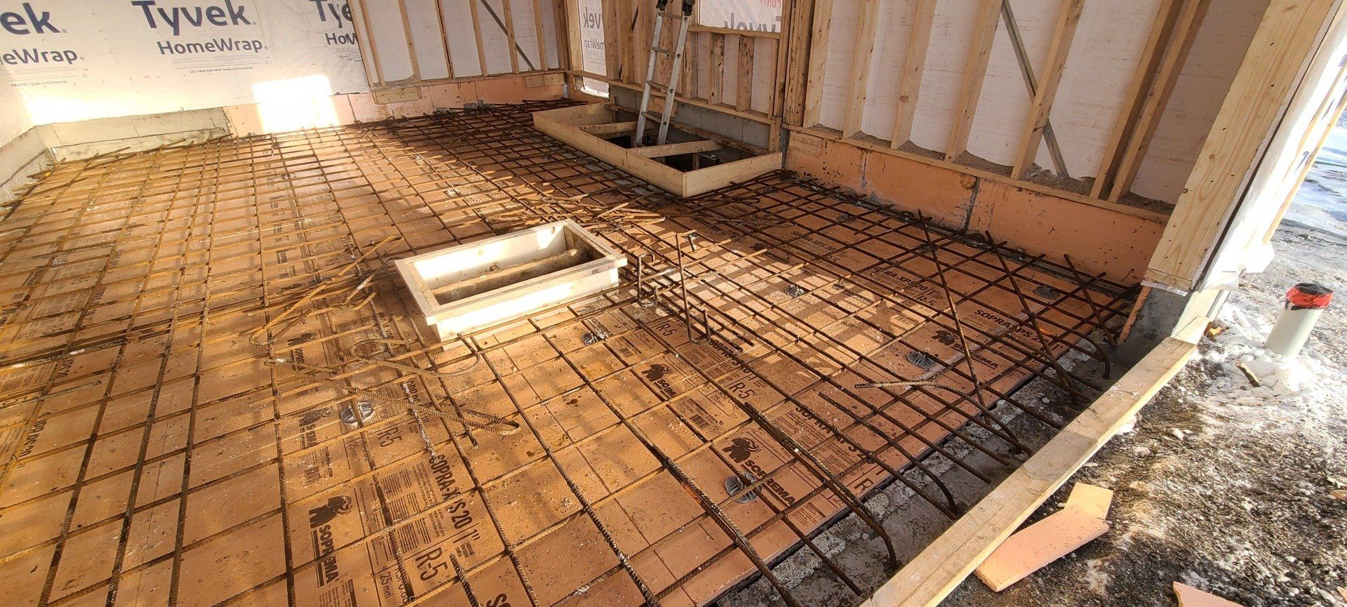 Un sol en béton est en cours de construction dans un bâtiment en construction.