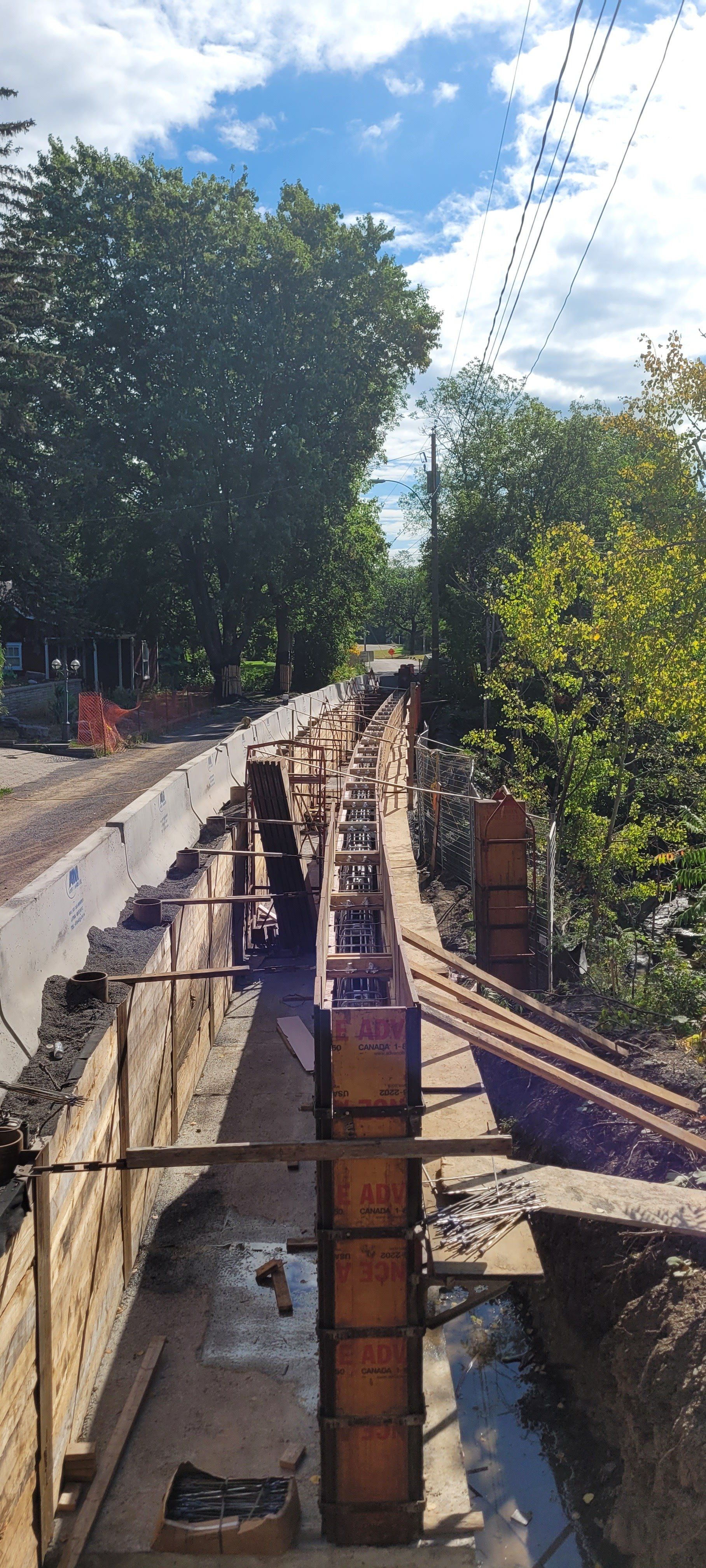 Un mur de béton est en cours de construction à côté d'une voie ferrée.