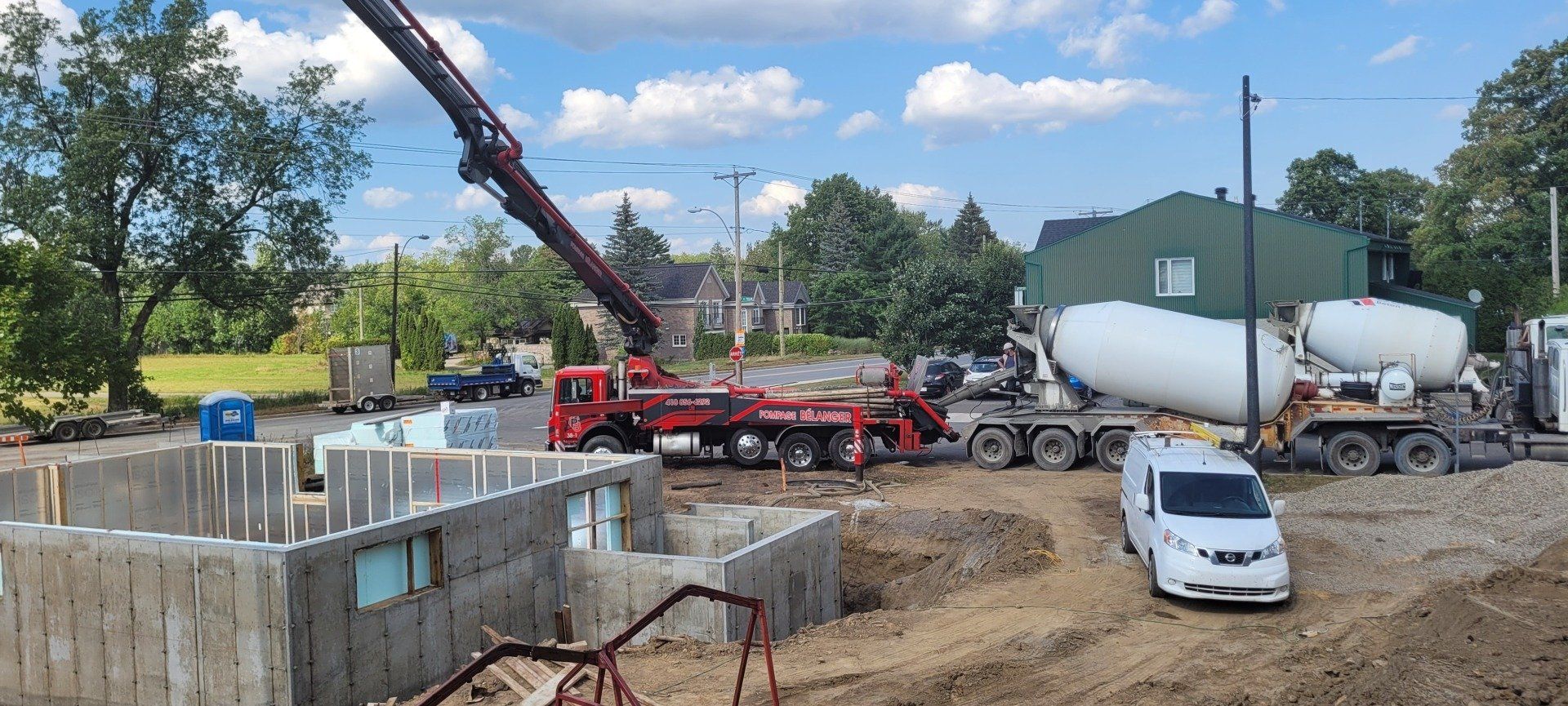 Un camion à béton verse du béton dans une fondation sur un chantier de construction.