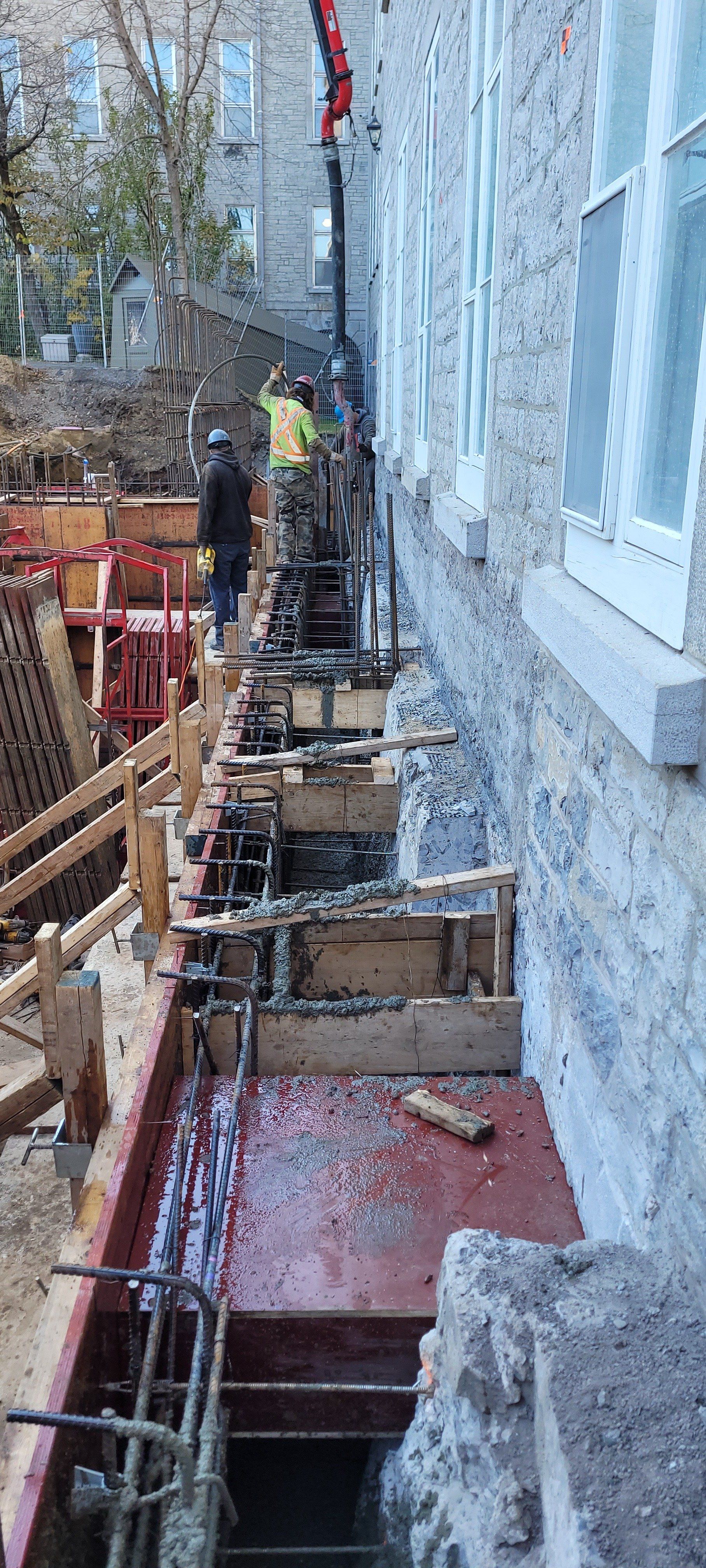 Un groupe d'ouvriers du bâtiment travaillent sur le côté d'un bâtiment.