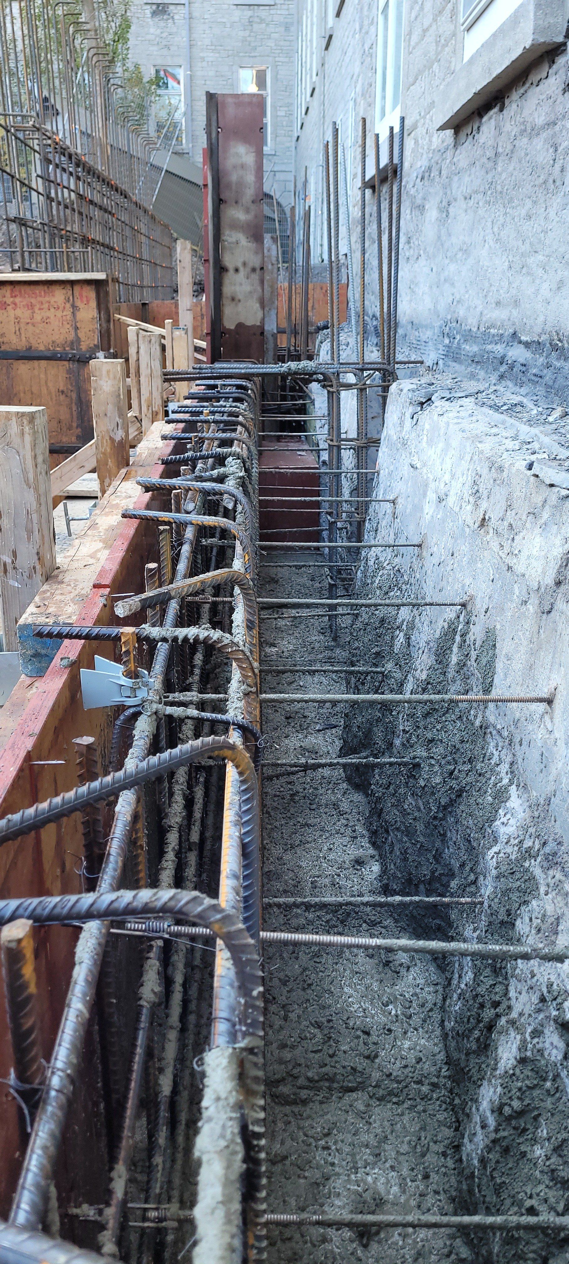 Un mur de béton est en cours de construction sur le côté d'un bâtiment.