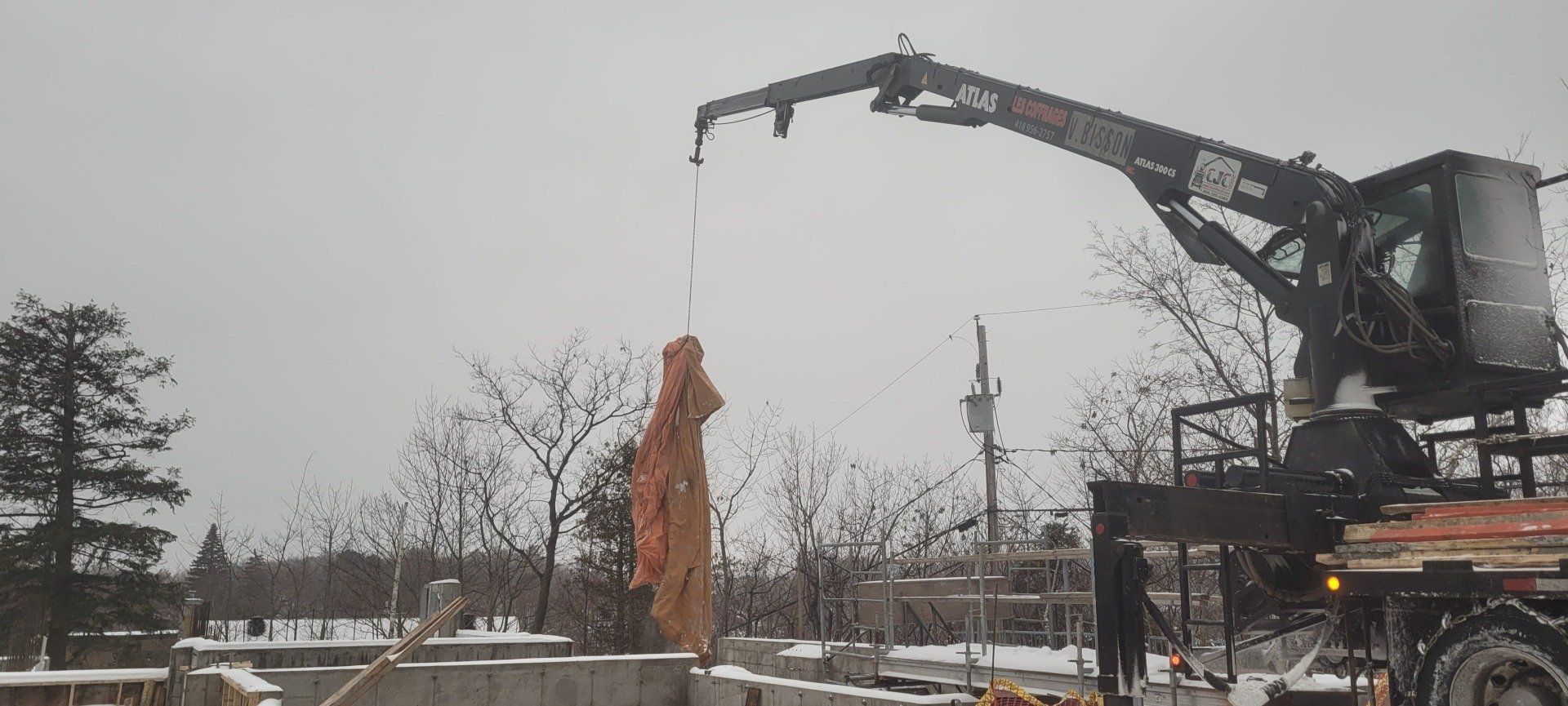 Une grande grue soulève un gros objet dans les airs.