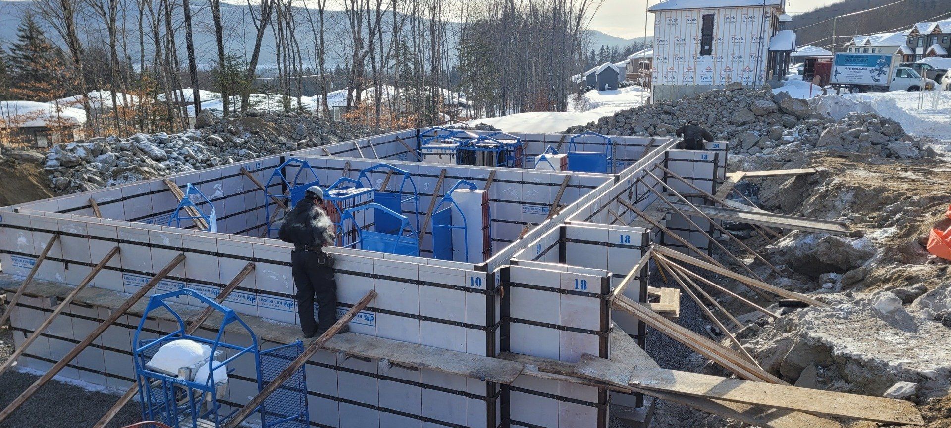 Un bâtiment est en train d'être construit dans la neige avec beaucoup de briques.