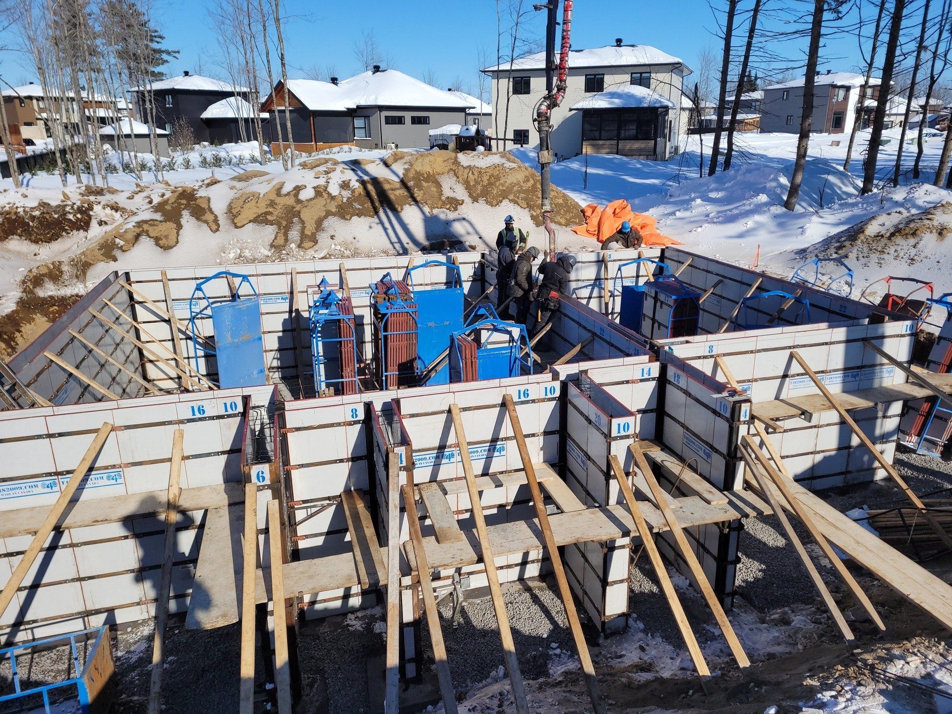 Un chantier de construction avec beaucoup d'échafaudages en bois dans la neige.