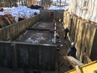 Un homme se tient devant un grand mur de béton.