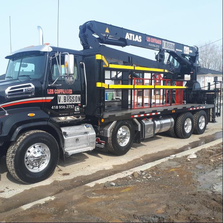 Un camion atlas noir est garé sur le bord de la route